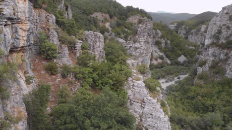 Drone-video-Flying-through-near-steep-rocks-on-a-wild-forest-at-Zagori-region-Greece-on-a-cloudy-day