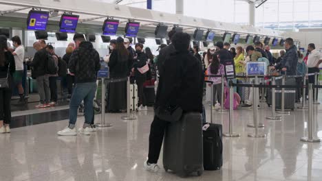 Chinese-passengers-check-in-at-an-airline-desk-counter-in-Hong-Kong's-Chek-Lap-Kok-International-Airport