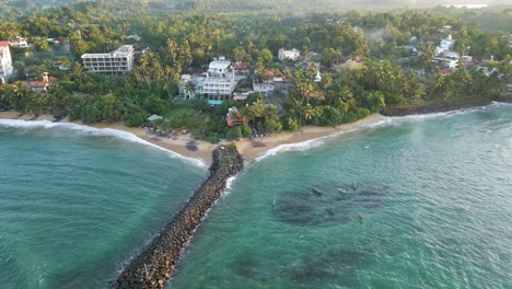 Rotatin-aerial-shot-of-Turtle-Bay-Beach-Resort-at-sunrise-in-Mirissa,-Sri-Lanka