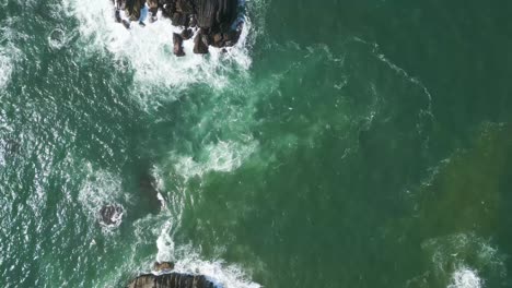 Topview-Aerial-of-washing-waves-in-a-rocky-ocean