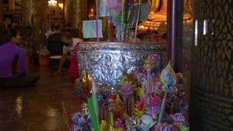 Panning-view-of-dana-flowers-with-money-attached-at-Buddhist-temple,-Phitsanulok,-Thailand