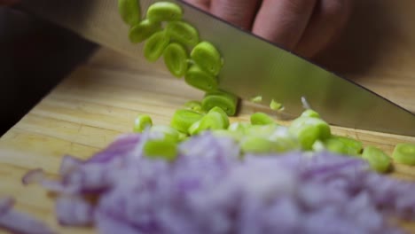 Cook-chives-and-red-onion-on-wooden-cutting-board