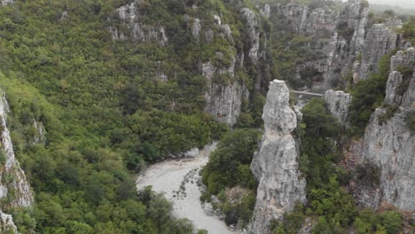 Drone-video-flying-following-the-gorge-canyon-between-steep-cliffs-rocks-revealing-2-arch-bridges-Kokori-Bridge-Zagori-Greece-panning-down