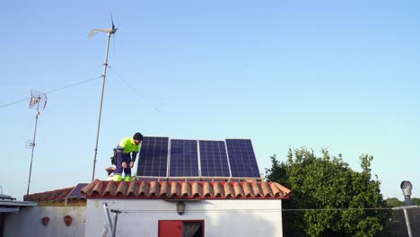 Static-Shot-Of-Technician-Checking-Solar-Panels-Fixed-Over-Bricked-Roof