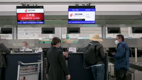 Passengers-check-in-at-the-Air-China-airline-desk-counter-in-Hong-Kong's-Chek-Lap-Kok-International-Airport