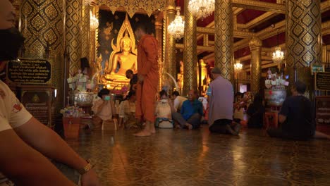 Monje-Posando-Para-Fotos-Con-Una-Familia-Asiática-Cerca-De-La-Estatua-De-Buda-En-El-Templo-Budista,-Tailandia