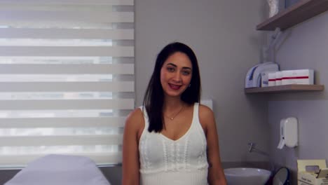 Hispanische-Ärztin-In-Ihrer-Praxis,-Die-Lächelnd-Auf-Die-Kamera-Zugeht