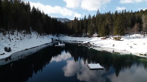 Aguas-Heladas-Del-Lago-Caumasee-Con-Bosques-De-Coníferas-En-Un-Soleado-Día-De-Invierno-En-Suiza