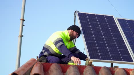 Close-Shot-Of-Technician-Guy-with-uniform-Installing-Solar-Panels-Over-Bricked-Roof