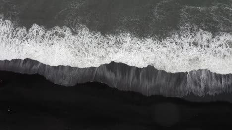 Aerial:-Top-down-shot-of-Reynisfjara-beach-big-waves