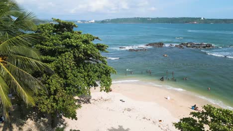 Die-Menschen-Genießen-Den-Strand,-Luftaufnahmen,-Kokospalmen-Und-Wellen-In-Sri-Lanka