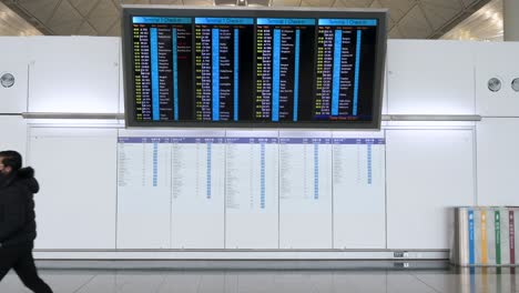 Ein-Reisepassagier-Läuft-An-Einem-Check-in-Bildschirm-Einer-Fluggesellschaft-In-Der-Abflughalle-Des-Internationalen-Flughafens-Chek-Lap-Kok-In-Hongkong-Vorbei