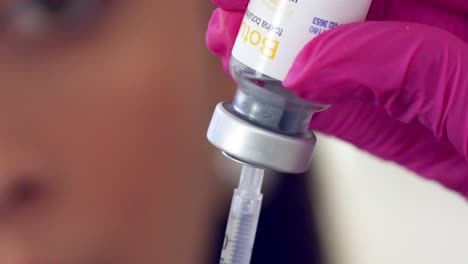 Female-medical-professional-filling-a-syringe-with-Botox---close-up