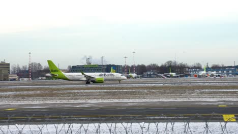Airbaltic-Avión-Sobre-Asfalto-Antes-De-La-Salida-En-El-Aeropuerto-De-Riga,-Letonia