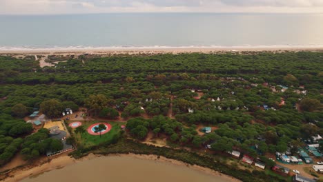 Areal-view-of-beach-with-small-camping-settlement-with-fun-park-for-tourist-at-Huelva-beach,-Spain