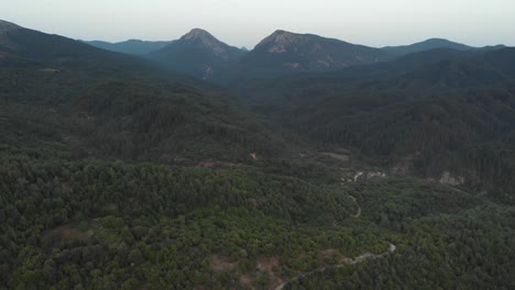 Drone-Video-over-dense-forest-mountain-peaks-sunset-dusk-dirt-roads-Greece-Zagori