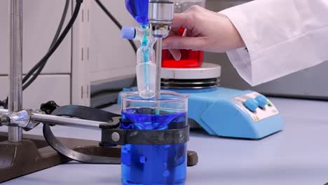 Mixing-blue-an-red-liquid-in-a-laboratorie