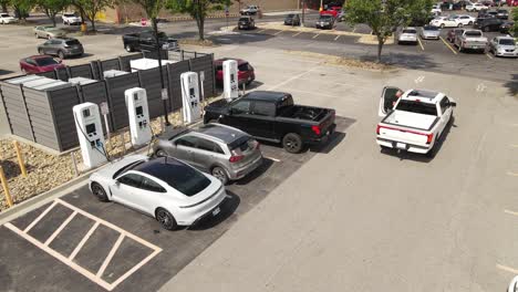 Electric-cars-charging-in-local-charging-station-in-USA,-aerial-drone-view