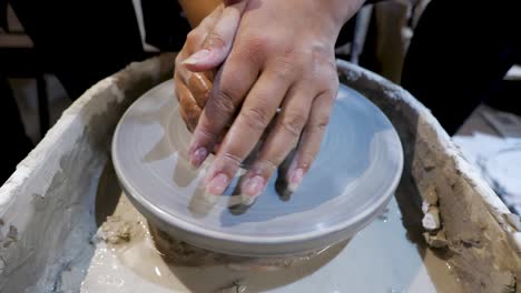 overhead-close-view-of-an-African-American-hands-spinning-clay-very-sporadically-while-pushing-the-mold-from-above