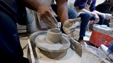 overhead-close-view-of-an-African-American-hands-spinning-clay-very-sporadically-while-taking-a-pottery-class-in-the-city
