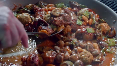 Cook-stirs-ingredients-to-make-Spanish-paella