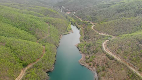 Video-De-Drones-Volando-Sobre-Un-Lago-De-Montaña,-Camino-De-Tierra-Del-País