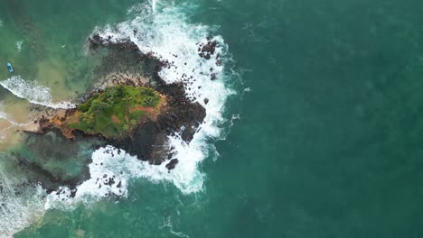 Cenital-aerial-shot-over-the-sea-and-the-beach-of-Parrot-Rock,-Mirissa,-Sri-Lanka-at-Sunrise