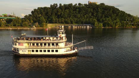 Ferry-boat-transporting-people-for-tour-in-Tennessee-river,-aerial-orbit-view