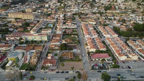 Aerial-shot-advancing-over-the-city-in-Malaga,-Spain:-buildings,-houses-and-a-construction-site-with-a-crane
