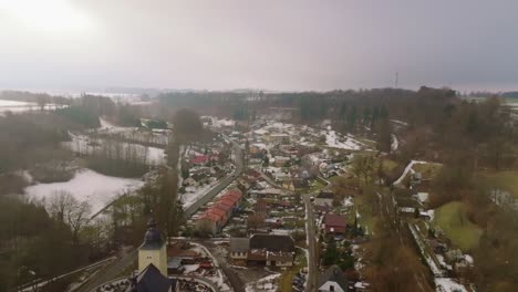 Aerial-wide-landscape-shot-of-the-snowy-Vendolí-Vilalge-in-Czech-Republic-during-a-sunny-winter-day