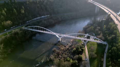 Luftaufnahme-über-Einer-Brücke-Im-Fluss-Miño-In-Spanien,-Autobahn,-Tolle-Vegetation,-Horizont-Mit-Bergen-Und-Blauem-Himmel