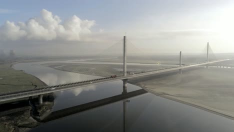Energy-icon-overlay-following-electric-vehicle-crossing-Mersey-gateway-bridge-aerial-view
