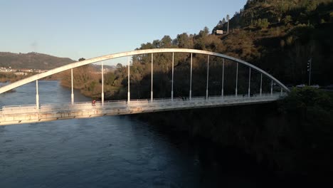 Luftaufnahme-über-Einer-Brücke-Mit-Fußgängern,-Die-Darauf-Im-Fluss-Miño-In-Spanien-Laufen
