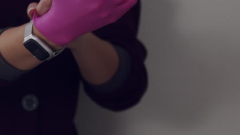 Female-doctor-putting-on-latex-gloves-for-Botox-treatment---isolated-close-up-in-slow-motion