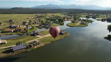 Aerial-View-of-Hot-Air-Balloon-Flying-Above-Village-Lake-in-Pagosa-Springs,-Colorado-USA