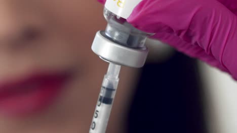 Filling-a-syringe-with-clear-medication-for-an-injection---close-up
