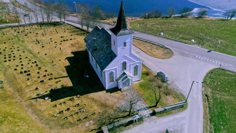 White-color-church-on-lake-coastline,-aerial-drone-view
