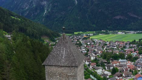 Aerial-shot-over-Castle-Taufers-in-Trentino-Alto-Adige-in-Italy,-landscape-of-a-village-in-a-wooded-valley-between-mountains