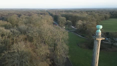 Aerial-view-passing-National-trust-Bridgewater-monument-autumnal-trees-towards-Ashridge-estate-carpark