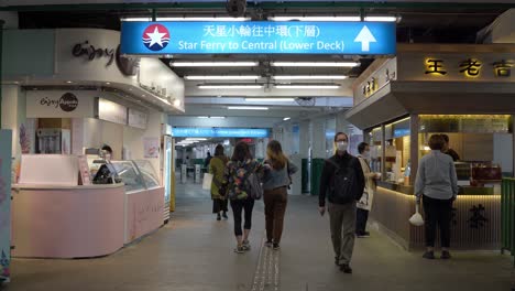 Entrance-to-star-ferry-with-pedestrians-walking-in-Tsim-Sha-Tsui,-Hong-Kong