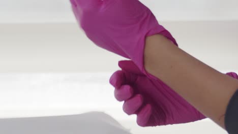 Close-up-of-a-female-doctor-putting-on-latex-gloves