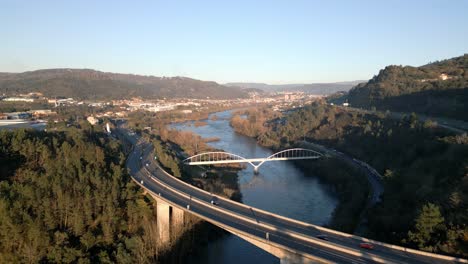 Luftaufnahme-über-Einer-Brücke-Und-Einer-Autobahn-Im-Fluss-Miño-In-Spanien,-Tolle-Vegetation,-Horizont-Mit-Bergen-Und-Blauem-Himmel