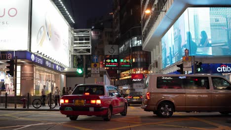Menschen-Und-Autos-Auf-Einer-Belebten-Straße,-Beleuchtet-Von-Werbetafeln