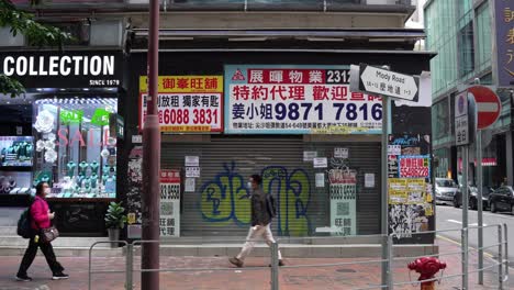 Mietanzeigen-Und-Plakate-In-Geschäften-In-Tsim-Sha-Tsui-Auf-Der-Straße-Und-Asiatische-Fußgänger-Mit-Gesichtsmasken-Im-Umlauf