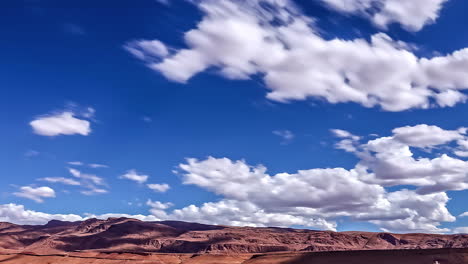 Blue-sky-and-fluffy-clouds-above-desert-area,-fusion-time-lapse