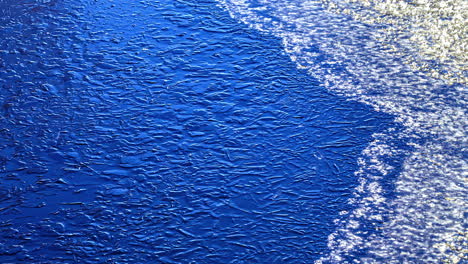 Eis-Schmilzt-Von-Der-Blauen-Farboberfläche,-Zeitrafferansicht-Der-Fusion