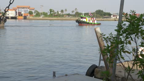 Tug-boat-with-Thailand-flag,-green-white-ship-on-river