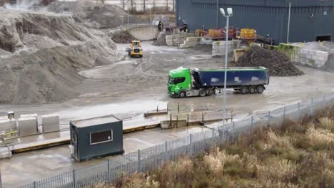 Truck-parking-waiting-for-excavator-digger-to-load-alongside-British-power-station-weigh-station
