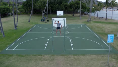 Junge-Sitzt-Auf-Dem-Basketballbrett-Auf-Dem-Tropical-Court-In-Hawaii