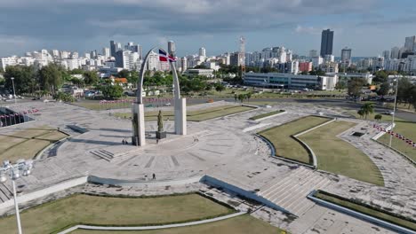 Aerial-orbit-shot-of-Plaza-de-la-Bandera-in-Santo-Domingo-with-skyline-in-background